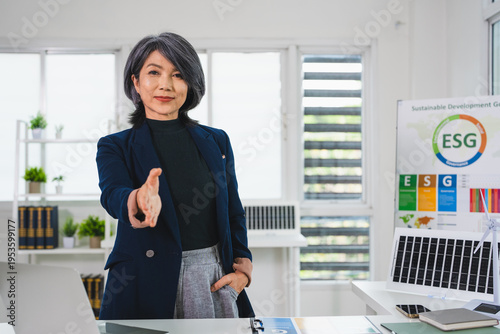 Asian  businesswoman with handshake gesture. stretching hand for shaking, looking at camera, smiling, offering, contract, partnership for ESG Project with a smile.