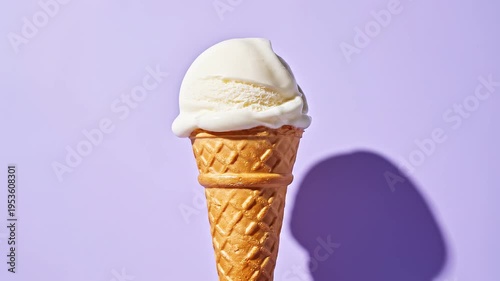 Refreshing scoop of creamy vanilla ice cream in a crisp waffle cone, highlighted on a vibrant purple background with a distinct shadow, a sweet and cool dessert