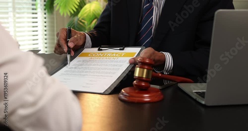 Lawyer explaining contract agreement to client in office while reviewing legal documents, representing legal consultation, justice process, and professional legal services.