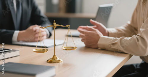 The scale on the desk symbolizes fairness and justice, and the conversation between two business people presents a professional legal consultation atmosphere, making it a material image suitable for l