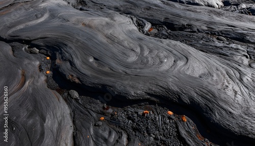 Hardened dark volcanic lava flow with abstract texture of ripples and curves
