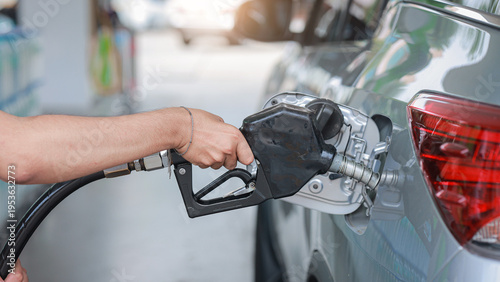 Φωτογραφία Person uses pump to put gasoline into vehicle tank feeling stressed by rising fu
