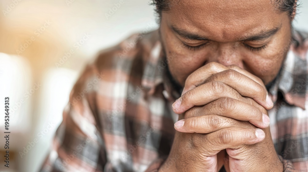 Fototapeta premium Man praying with hands clasped together. Devoted person showing faith and spiritual connection. Religious concept of hope, belief, humility and meditation. Human emotion and peace.