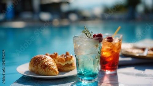 Chilled cocktails and delicious pastries on a sunny poolside table offer the perfect summer relaxation ambiance.
