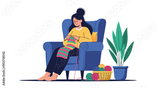 Relaxed woman sitting in a blue armchair knitting a colorful scarf at home for a creative hobby and leisure activity.