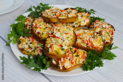 Foto Delicious, quick, mouth-watering hot sandwiches with crab sticks, cheese and green onions