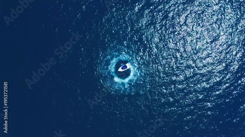 Aerial View of Motorboat Completing Circle Maneuver on Glittering Blue Ocean