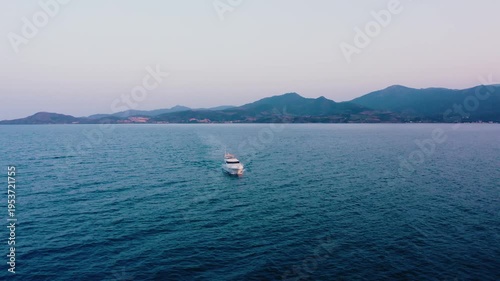 Front View of Luxury Yacht Navigating Mediterranean Sea with Mountain Backdrop