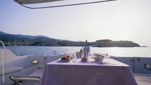 Luxury Yacht Deck Table with Food and Champagne Facing Coastal Village