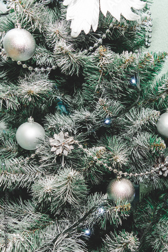 The Christmas tree is decorated with silver-colored toys.