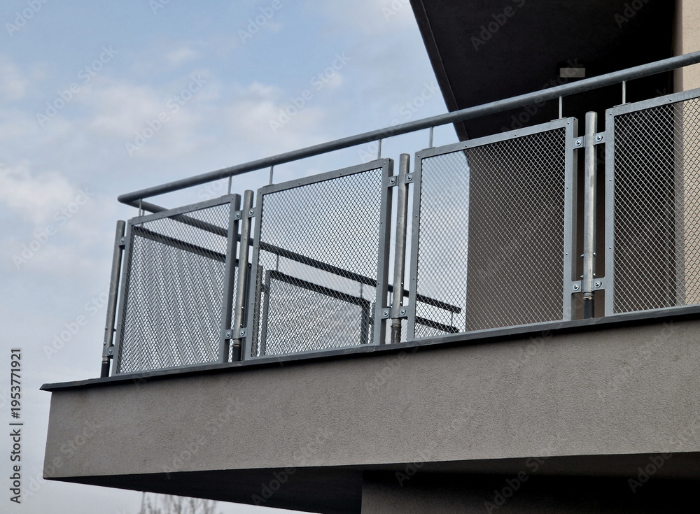 Fototapeta premium modern balcony railing with expanded metal infill. This type of infill is popular in architecture for its combination of safety, airiness and ability to provide privacy without completely blocking the