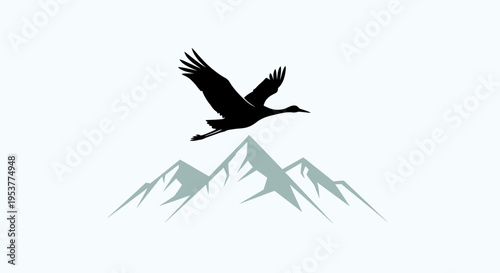 Silhouette of a majestic crane bird flying over snowcapped mountains.