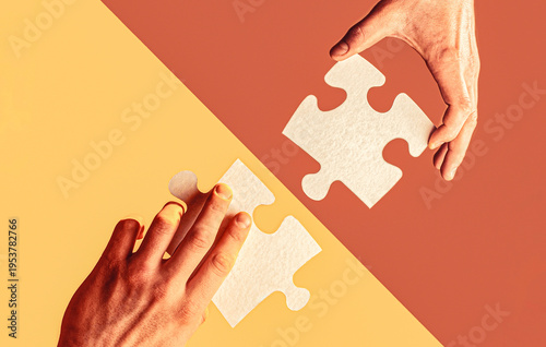 Two hands trying to connect couple puzzle piece. Two puzzle pieces. Human hands holds, putting together puzzle pieces