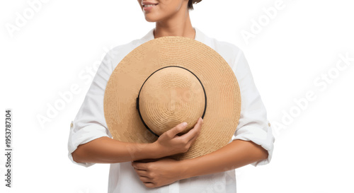 Woman in white shirt holding stylish straw hat close to her chest