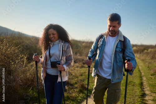Konstfotografi Happy mixed race couple enjoying a refreshing nordic walking activity on a natur