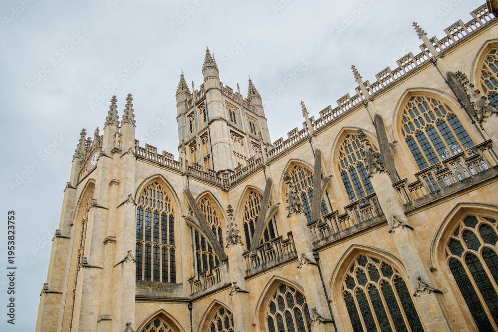 Fototapeta premium Bath England: 27th July 2025: look up at Bath Abbey's tall stone structure featuring intricate designs. The scene captures the impressive size and craftsmanship of this historic church