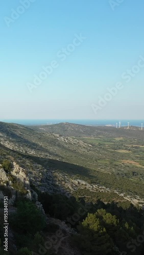 Wide view of rugged hills covered in greenery with the sea visible on the horizon under a clear blue sky. Peaceful natural landscape, possibly near the English Channel.