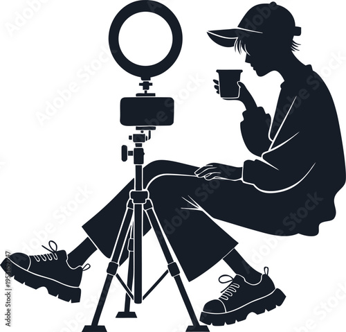 Young person with cap drinking from cup during livestreaming with ring light