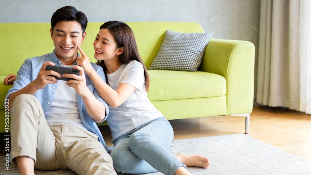 Fototapeta premium Couple playing game on phone on couch