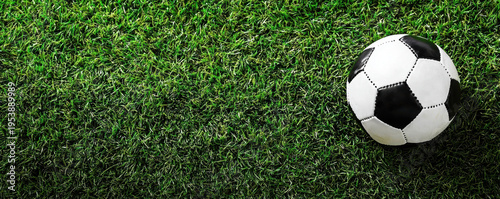 Wallpaper Mural Black and white soccer ball on green grass field, top view with vibrant texture and natural light creating lively sports atmosphere Torontodigital.ca
