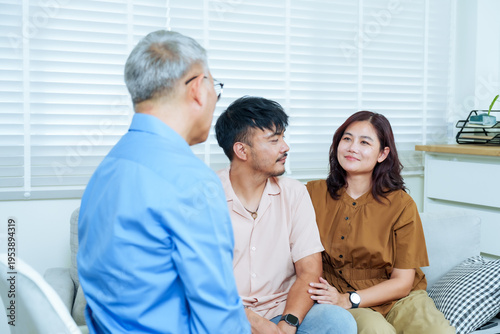 Obraz na plátne asian couple smiling warmly during final part counseling session with senior psy