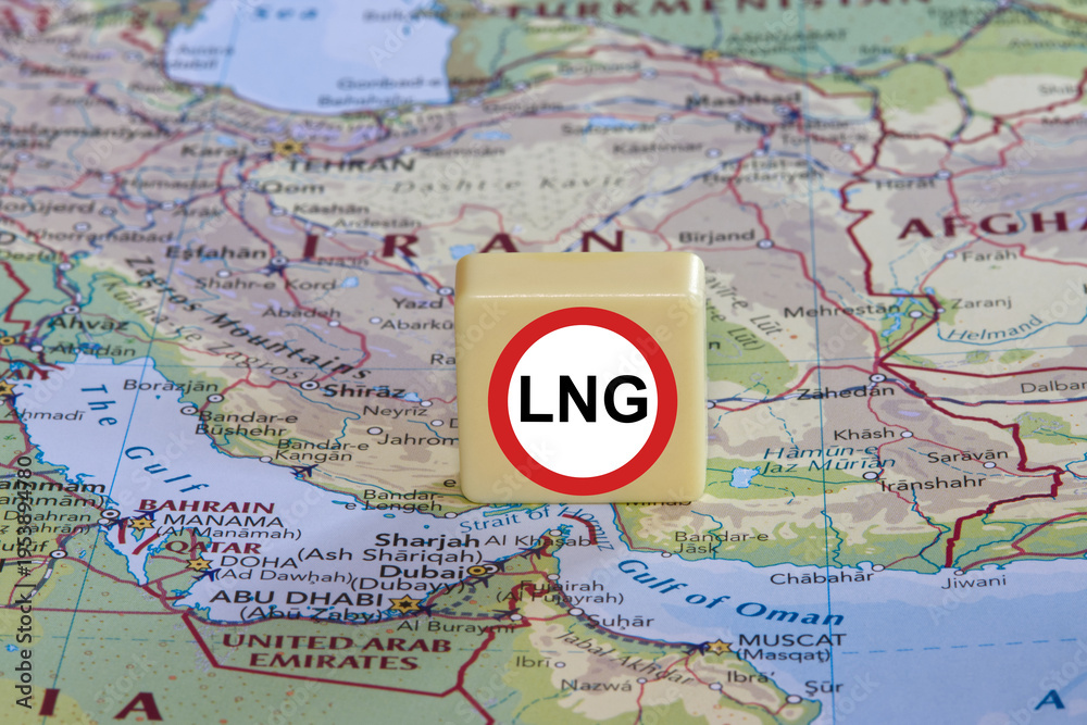 Naklejka premium Prohibition of transit transportation of LNG sign on a plastic box near the Strait of Hormuz on a map, close-up.