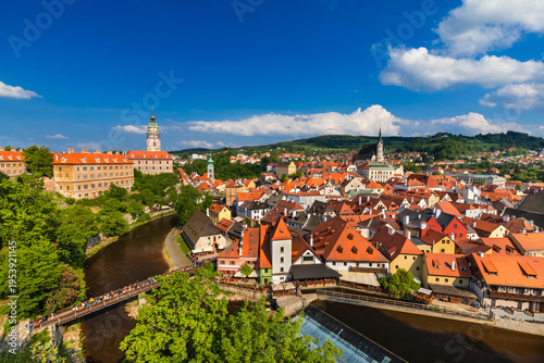 A stunning aerial drone view of Cesky Krumlov in the Czech Republic, showcasing its historic old town, red rooftops, and the winding Vltava River. This UNESCO World Heritage site features picturesque 