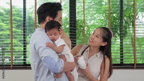 Family Bonding: A heartwarming moment as a father cradles his newborn, while the mother lovingly gazes, creating a scene of tenderness and affection.Capturing the deep connections of family.