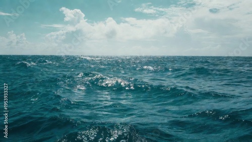 Open ocean seascape with sunlit waves and cloudy sky for background wallpaper and banner design