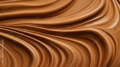 Smooth chocolate waves flow across a surface with ripples and swirls creating a rich dessert texture