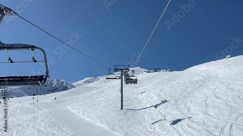 Ski lifts going up and down in Courchevel ski resort, French alps, France on a sunny blue sky day