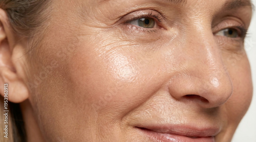 Smooth cheek with fine lines near eye corner, close-up aging skin photo.