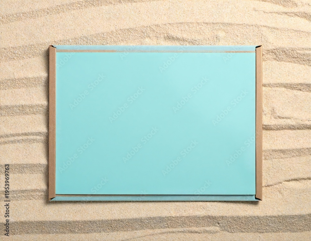 Fototapeta premium a single weathered blue ceramic tile resting on smooth golden sand under soft natural light