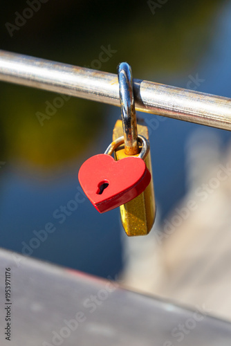 Fotografía Small red heart padlock attached to love lock on bridge rail.