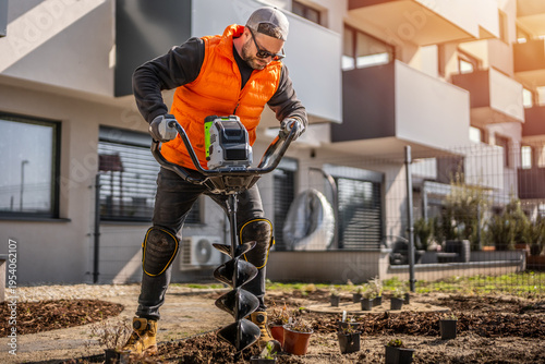 Vászonkép Gardener using tools hand-held soil hole drilling machine or portable manual cordless earth auger for prepare the soil for planting plants