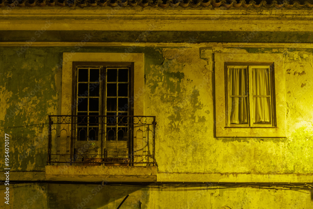 Obraz premium Old building facade with balcony and window at night