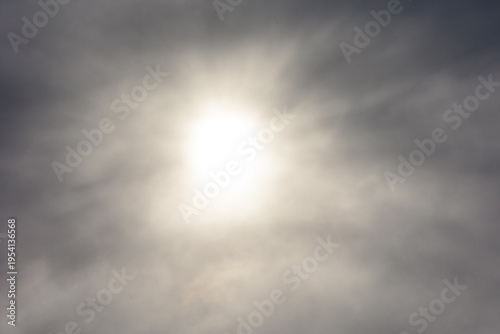 Bright Sun Behind Thin Clouds Creating Atmospheric Light Rays