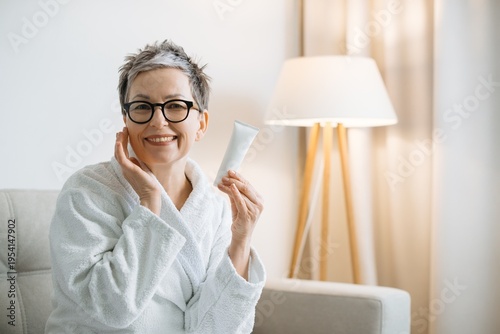 Bild auf Leinwand Mature woman applying skincare cream for self care