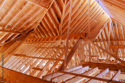Structure of wooden beams rafters in house under construction