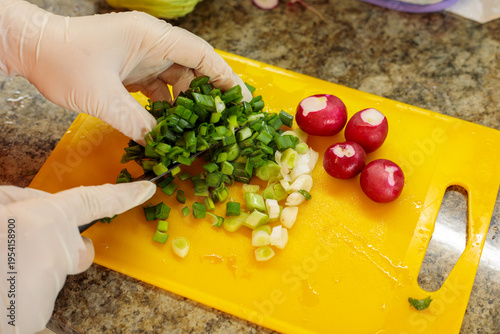 Cuadro en lienzo close up of hands slicing fresh green onion on cutting board in kitchen, prepari