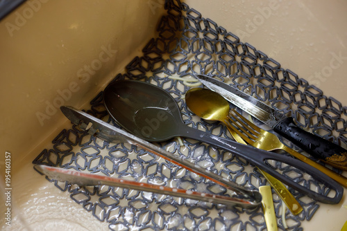 close up of male hands cleaning metal kitchen utensil with sponge under running water in sink household washing process with foam