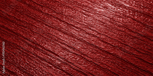 A close up view of a deep red surface featuring a rough diagonal texture and subtle light reflection