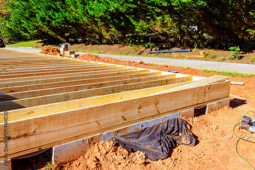 Construction of wooden deck frame takes place in residential area