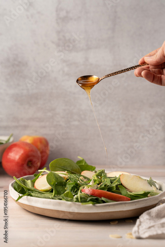 Pouring honey on apple salad fresh healthy food