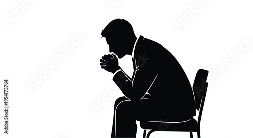 Sad businessman sitting alone in chair with head down feeling depressed or stressed in office setting
