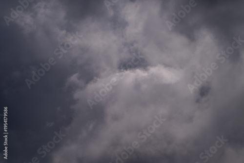 Tableau sur toile a dramatic sky filled with thick, dark grey storm clouds and patches of lighter, turbulent cumulus clouds under moody, natural light