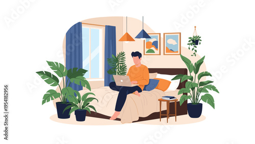 Young man working on his laptop while sitting in bed in a stylish bedroom decorated with many large tropical house plants.