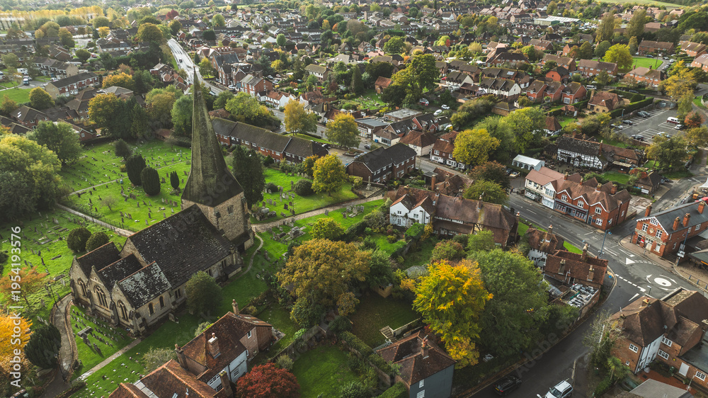 Αυτοκόλλητο Aerial view of a quaint English village with a historic church and spire surroun