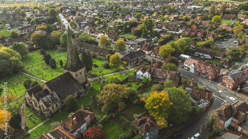 Foto Aerial view of a quaint English village with a historic church and spire surroun