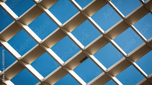 A modern architectural ceiling with a grid pattern against a blue sky